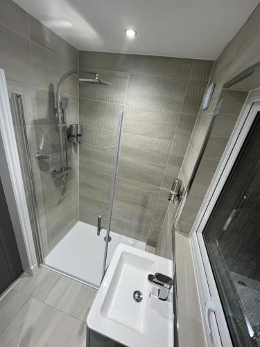 a bathroom with a shower and a white sink at LUXERY 1 Bedroom Apartment - Falkirk in Falkirk