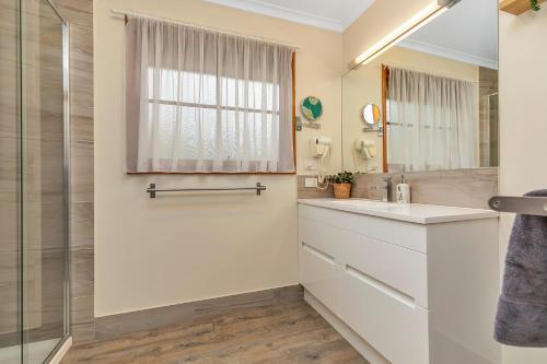 a bathroom with a sink and a shower at Riverfront Escape - Pool Fun and Space for Everyone in Moama