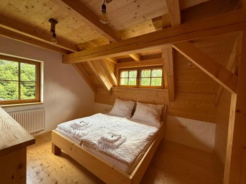 a room with a bed in a wooden house at Výtoň 263 in Přední Výtoň