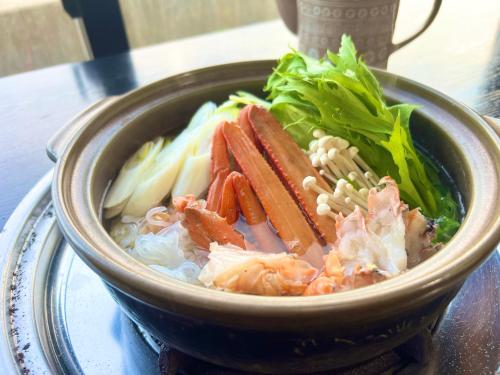 a bowl of food with meat and vegetables on a table at 坂本屋旅館 in Kyotango