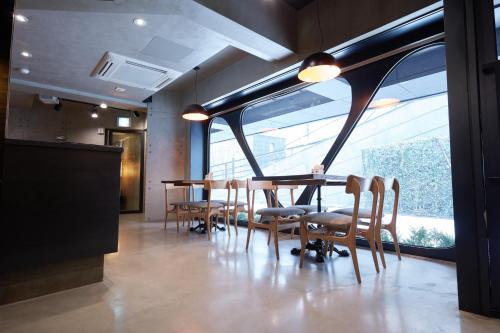 a table and chairs in a room with a large window at Tria Business & Boutique Hotel in Seoul