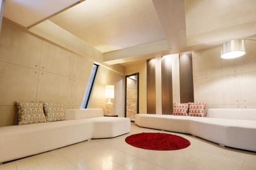 a living room with two white couches and a red rug at Tria Business & Boutique Hotel in Seoul