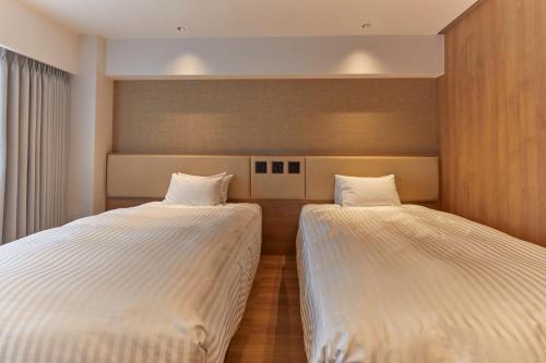 two beds sitting next to each other in a room at Hotel Stelle Belle in Hakuba