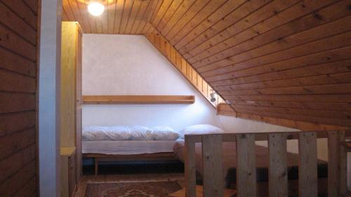 a small bed in a room with a wooden ceiling at Chalupa Pribylina in Pribylina