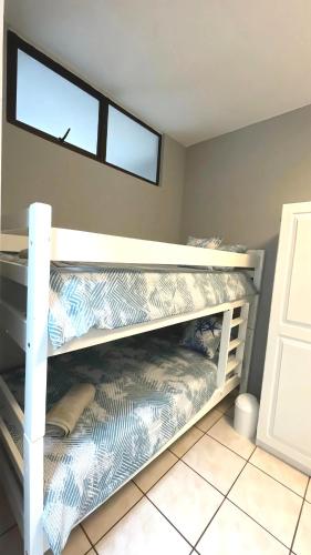 a bunk bed in a room with a window at Uvongo Cabanas, Manaba Beach in Margate