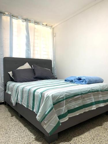 a bed with a green and white comforter in a bedroom at Comfort and an excellent area in Venezuela in Maracaibo