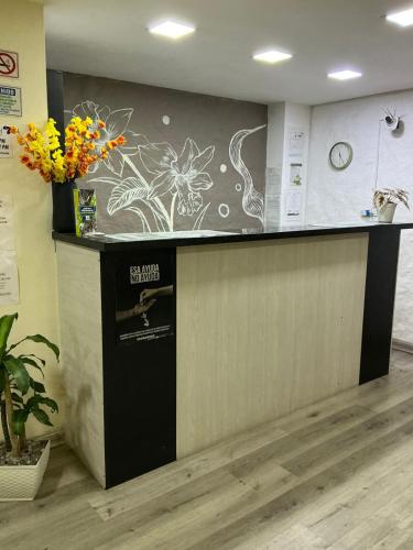 a lobby with a counter with flowers on the wall at HOTEl LAS FLORES in Santa Rosa de Cabal