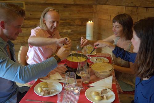 a group of people sitting around a table eating food at Alpenresort Eienwäldli Engelberg in Engelberg