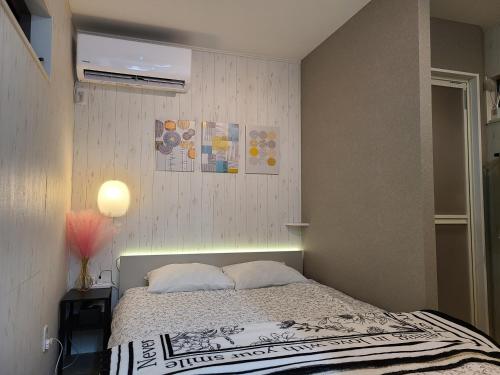 a small bedroom with a bed and a air conditioner at Greci Art Tokyo-Kinshicho Area Private room- in Tokyo