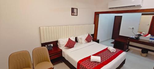 a hotel room with a bed and a desk and a desk at Aswin Residency in Nāmakkal