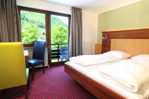 een hotelkamer met een bed en een balkon bij Hocheck in Altmünster