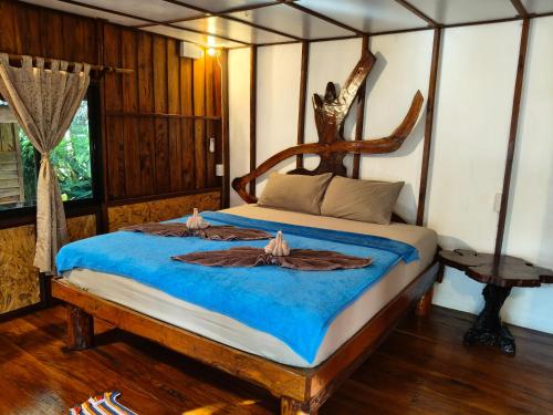 a bedroom with a large bed with a wooden headboard at Friendly Koh Jum in Ko Jum