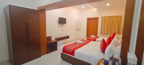 a bedroom with a bed and a tv on the wall at Aswin Residency in Nāmakkal