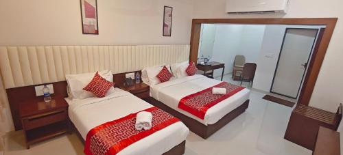 a hotel room with two beds and a mirror at Aswin Residency in Nāmakkal