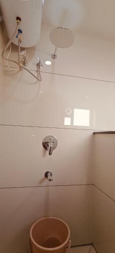 a white bathroom with a toilet and a sink at Aswin Residency in Nāmakkal