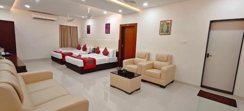 a hotel room with two beds and a living room at Aswin Residency in Nāmakkal