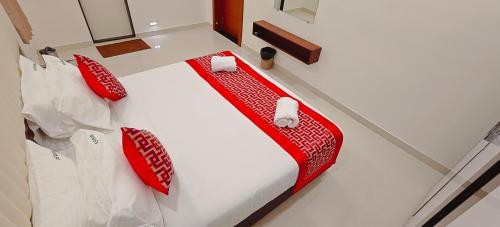 a bed with red and white sheets and pillows at Aswin Residency in Nāmakkal
