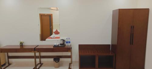 a bathroom with a desk and a mirror and a cabinet at Aswin Residency in Nāmakkal