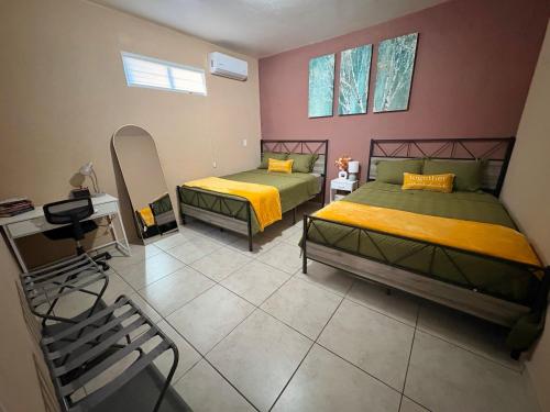 una camera da letto con due letti e uno specchio di The Casita a San Luis Río Colorado