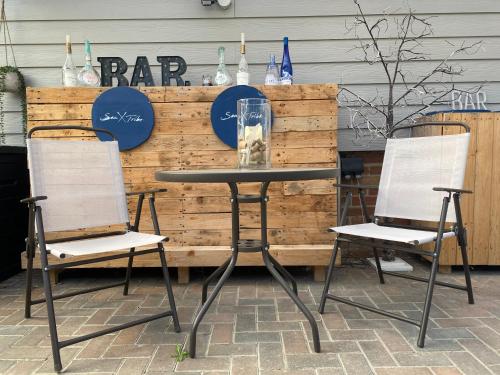 two chairs and a table with a table and two chairs at Seatribe Cabin, Cozy snug by the Sea in South Hayling