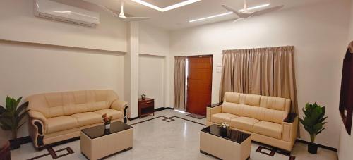 a living room with two couches in a room at Aswin Residency in Nāmakkal