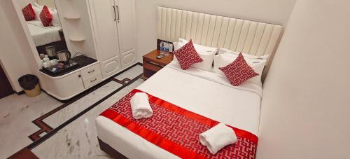 a bedroom with a large bed with red and white pillows at Aswin Residency in Nāmakkal