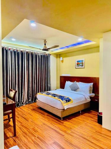 a bedroom with a bed and a desk and a bed sidx sidx sidx at Blue Wave Hotel Maldives in Kudahuvadhoo