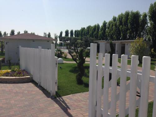 a white fence in front of a yard at Hotel Bussana in Porto Tolle
