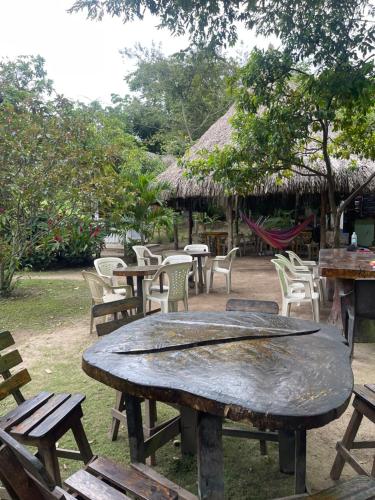 a large wooden table with chairs and tables at Zirumake Hostel Dentro del Parque Tayrona in El Zaino