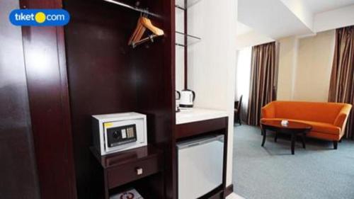 a hotel room with a tv and a couch at Asialink Premier in Karawang