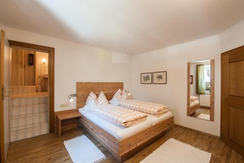 1 dormitorio con 1 cama grande y espejo en Appartements Al Castagno en Ehrwald