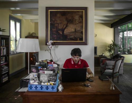 a man sitting at a desk using a laptop computer at Alloggio Al San Girolamo in Longiano