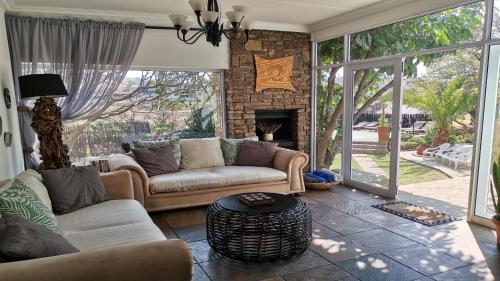 a living room with two couches and a fireplace at Guesthouse Terra Africa in Windhoek
