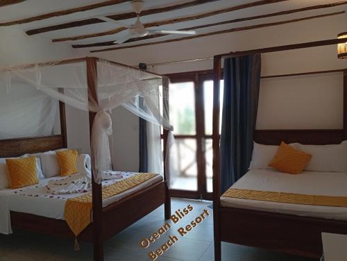 a bedroom with two beds and a window at Ocean Bliss Beach Resort in Pongwe
