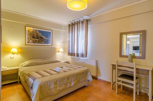 a bedroom with a bed and a desk and a chair at Plaka Studios in Karfas