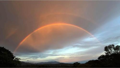 a rainbow formation in the sky at sunset at Colors Hostal in Boquete