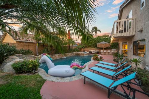 a pool with a inflatable swan in a backyard at Entire Private 4-BR w Pool, Hot Tub, King Bed, Garage, Available Now in El Cajon