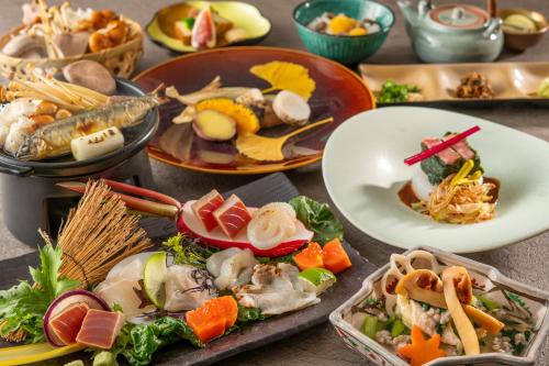 a table with many plates of food on it at KAMENOI HOTEL Nagatoro Yorii in Yorii