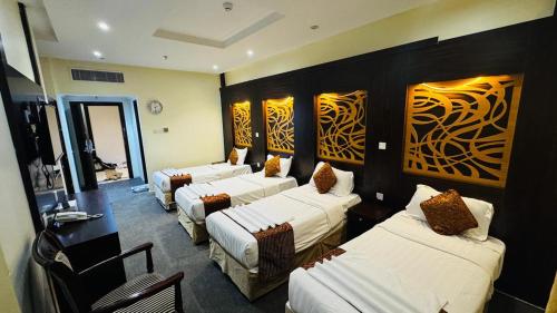 a room with four beds and couches in it at فندق اركان بكة in Al Khansāk