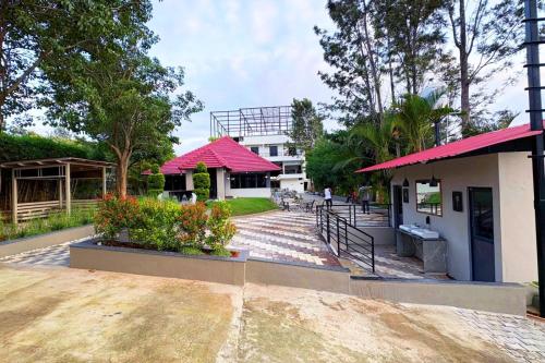 a building with a red roof and a walkway at The REEF LOUNGE in Mandya