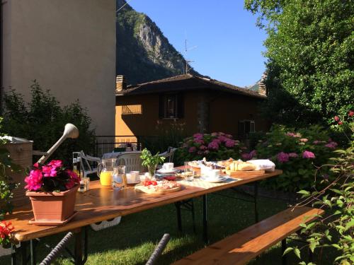 een picknicktafel in de tuin met eten erop bij Bed & Breakfast Casa Marinella in Lenna