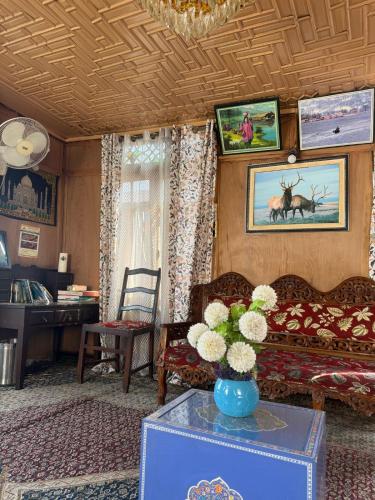 a living room with a couch and a table with flowers at Houseboat Lakeview Retreat in Srinagar