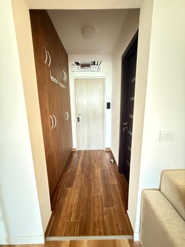 a hallway with a wooden floor and a door at ENE Studio in Oradea