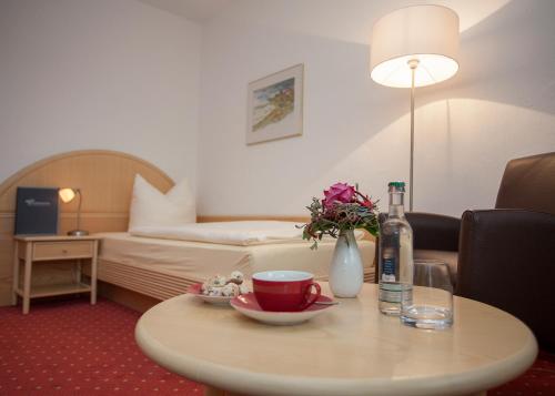 a hotel room with a coffee table and a bed at Hotel & Ferienappartements Edelweiss in Willingen