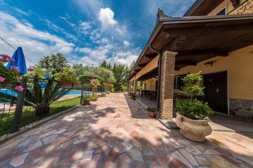 a brick walkway next to a building with a pool at B&B La Mortella in Albanella