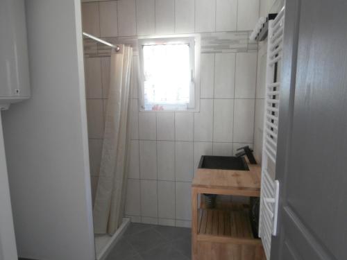 Un baño pequeño con lavabo y ventana. en La Mouchelière, en La Garde-Freinet