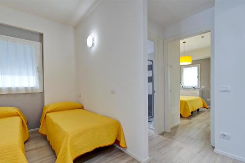 a bedroom with two beds with yellow sheets at Residence Armony in Misano Adriatico