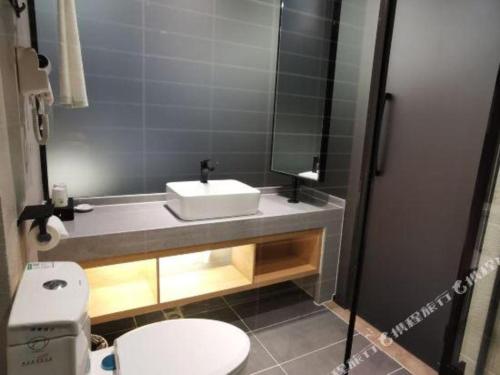 a bathroom with a sink and a toilet at GreenTree Inn Ganzhou Gan County Bus Station in Ganzhou