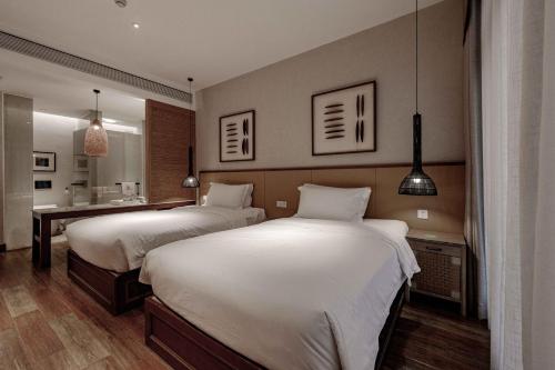 a hotel room with two beds and a bathroom at Ancient Charm Inn Chengdu in Chengdu