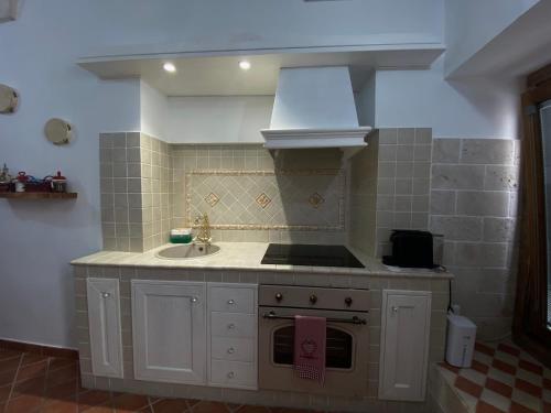 a kitchen with a sink and a stove top oven at La Casa della Pizzica in Ostuni